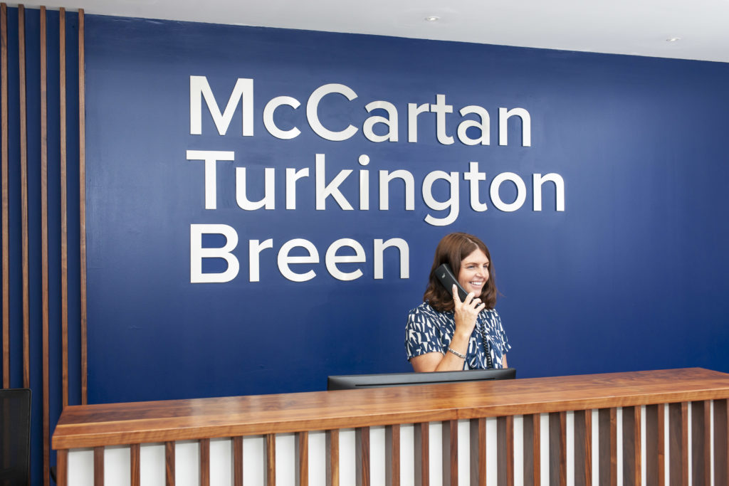 McCartan Turkington Breen's receptionist on the telephone at the offices of McCartan Turkington Breen in Belfast Northern Ireland